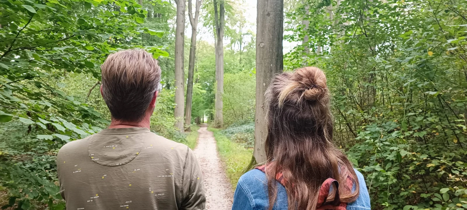 Samen wandelen op een bospad tijdens begeleiding in de natuur